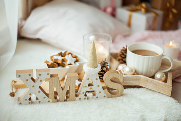 Christmas home decor in pink colors. Mug of hot cocoa, cookies, candle.