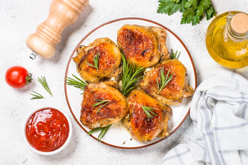 Baked chicken thighs with herbs on white plate.