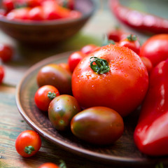 Close up of red healthy cherry tomatoes and paprika on wood