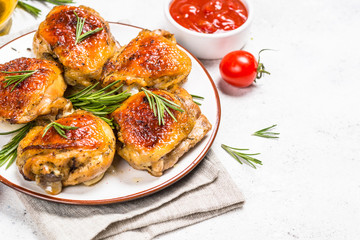 Baked chicken thighs with herbs on white plate.