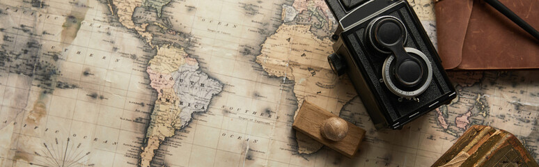 top view of vintage camera and stamp on map background, panoramic shot