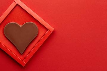 Valentines day chocolate heart on red background