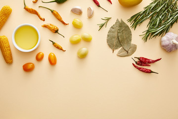Top view of vegetables, olive oil and rosemary on beige background
