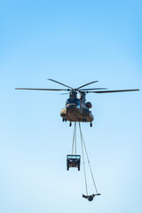 Fototapeta na wymiar 吊り下げ輸送をする軍用ヘリコプター
