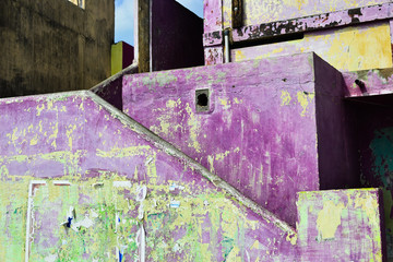 Fototapeta na wymiar Weathered grunge purple wall. Texture background grunge wall with torn posters. Kanyakumari, Tamil Nadu, India.