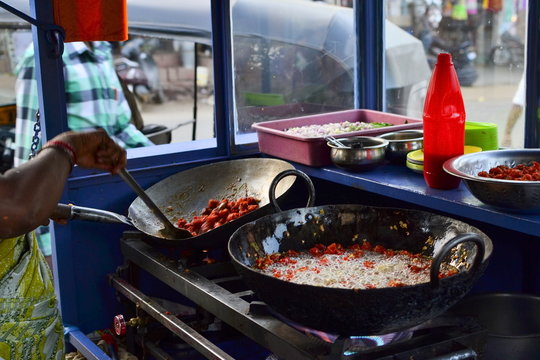 Street food stall with pans of fried food (pakora in boiling oil). Chitradurga, India
