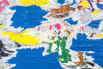 Closeup blue, white and yellow torn and peeling old paper posters and placards layers on dirty...