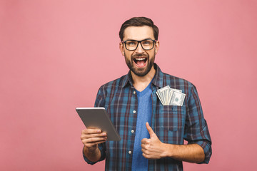 Portrait of happy handsome bearded young hipster man in checkered shirt standing, holding tablet...