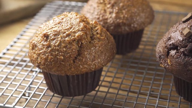 An assortment of muffins cooling on a rack.