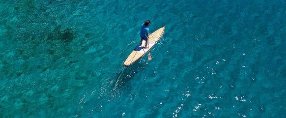 Aerial drone ultra wide photo of fit unidentified man practising in SUP board or Stand UP Paddle...