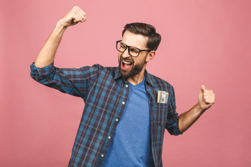 Young rich man in checkered shirt holding money dollar bills in the pocket with surprise isolated...