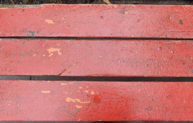 old shabby red painted park bench boards