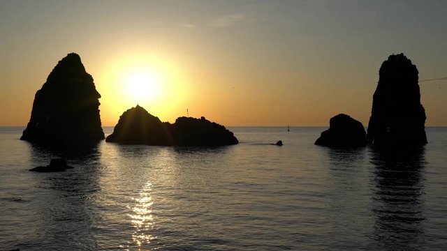 Alba sui faraglioni di Acitrezza, i luoghi del mito di Omero, Ulisse e Polifemo