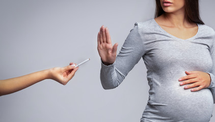 Pregnant woman refusing to take cigarette, panorama