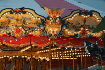 Riding around a horses carousel in winter night located on the Moscow Red Square. Chrismas Eve and New Year mood. Bright and colorful decoration of children' carousel.