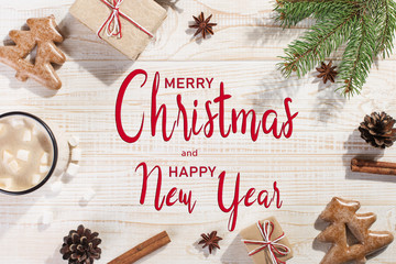 Hot Christmas drink with marshmallows in an iron mug, on a white table. Inscription, Merry Christmas and Happy New Year, greeting card copy space.