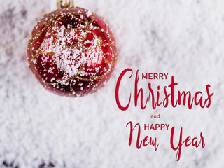Inscription, Merry Christmas and Happy New Year, Christmas ball toy on white snow, holiday symbol.