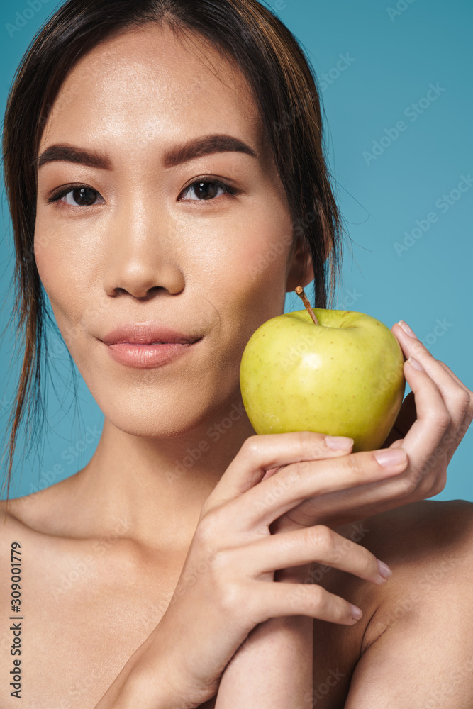 Poster Portrait of half-naked asian woman holding apple and looking at camera