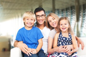 Beautiful smiling happy family siting on sofa