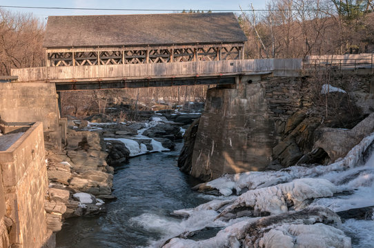 The Original Quechee Covered Bridge (Quechee, Vermont) In Winter, Before It Was Destroyed In August 2011 In The Flooding During Hurricane Irene. Ice And Snow Cover The Rocks In The Foreground.