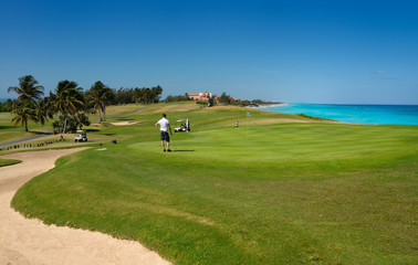 Fototapeta na wymiar Golfers playing the 18th Hole of the Varadero Golf Club Cuba