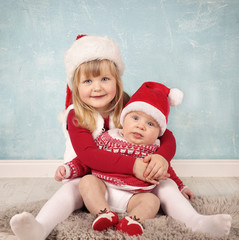 Geschwister kuscheln an Weihnachten
