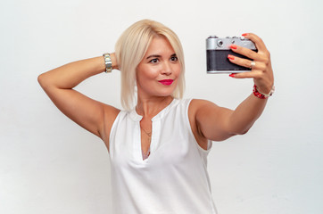 woman takes a photo with an old film camera. Age-related change, cosmetology.