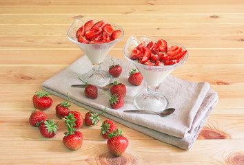 Homemade  italian dessert panna cotta with fresh strawberry served in ice cream glass bowls and...