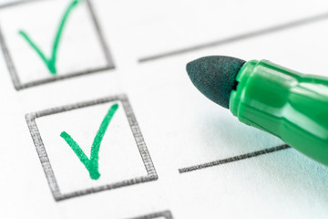 Сheck mark and green marker on white background. Checklist, quality service survey concept. Macro...