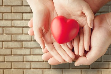 Fototapeta premium Man and woman holding red heart on background