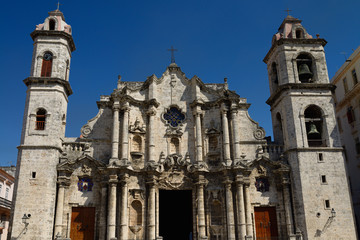 Front of the Havana Cathedral with clock and bell towers against a blue sky