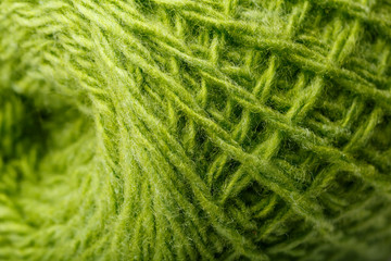Wool yarn close up colorful green threads for needlework in macro.