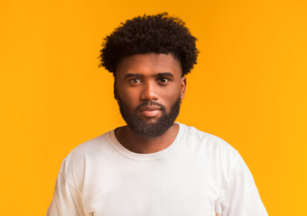 Young handsome black guy over orange background