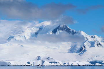 Fototapeta na wymiar Snow-capped mountains on an island along the coasts of the Antarctic Peninsula, Antarctica