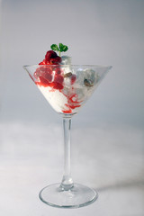 Delicious ice cream with forest fruit and mint leaves.