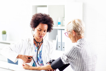 Doctor measure blood pressure in ambulance older woman