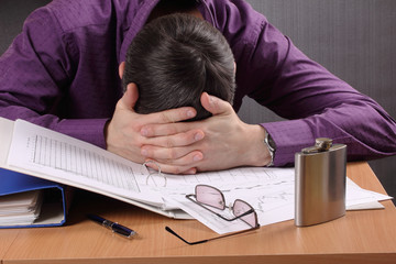 man tired of work, bowed his head to the table with documents
