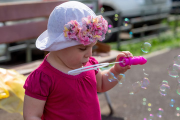 Little girl blowing soap bubbles