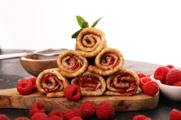 Delicious Tasty Homemade crepes or pancakes with raspberries and mint on rustic background
