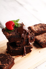 chocolate brownie cake dessert with raspberries and spices on a wooden background.