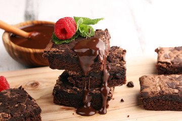 chocolate brownie cake dessert with raspberries and spices on a wooden background.