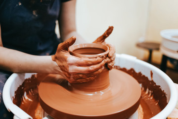 Woman is engaged in pottery. Potter in the process of creating a clay product