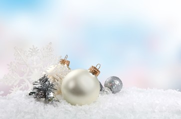 Silver and white christmas balls on white snow