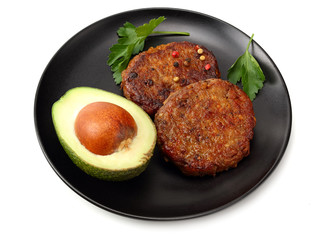 grilled burger meat with avocado on black plate isolated on white background. top view