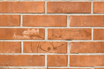 old orange brick wall texture background with traces of dried glue, close up.