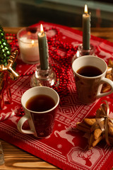 Obraz na płótnie Canvas Top view of cups of black tea with Christmas decoration and gingerbread cookies