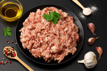 Mince. Ground meat with spices on black background. Top view
