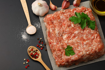 Mince. Ground meat with spices on black background. Top view