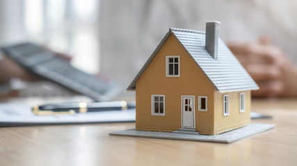 House model with agent and customer discussing for contract to buy, get insurance or loan real...