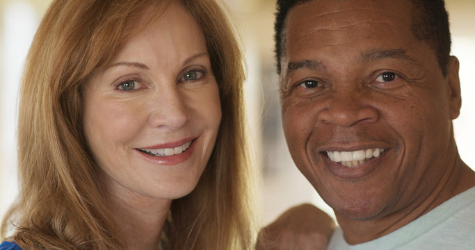 Close up portrait of smiling mixed race senior couple looking at camera